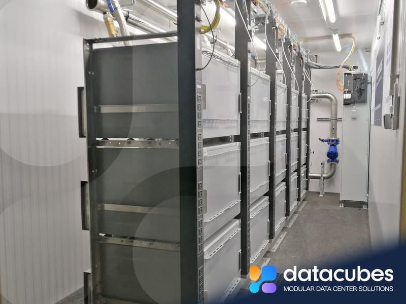 Immersion-cooled container interior with fluid tanks